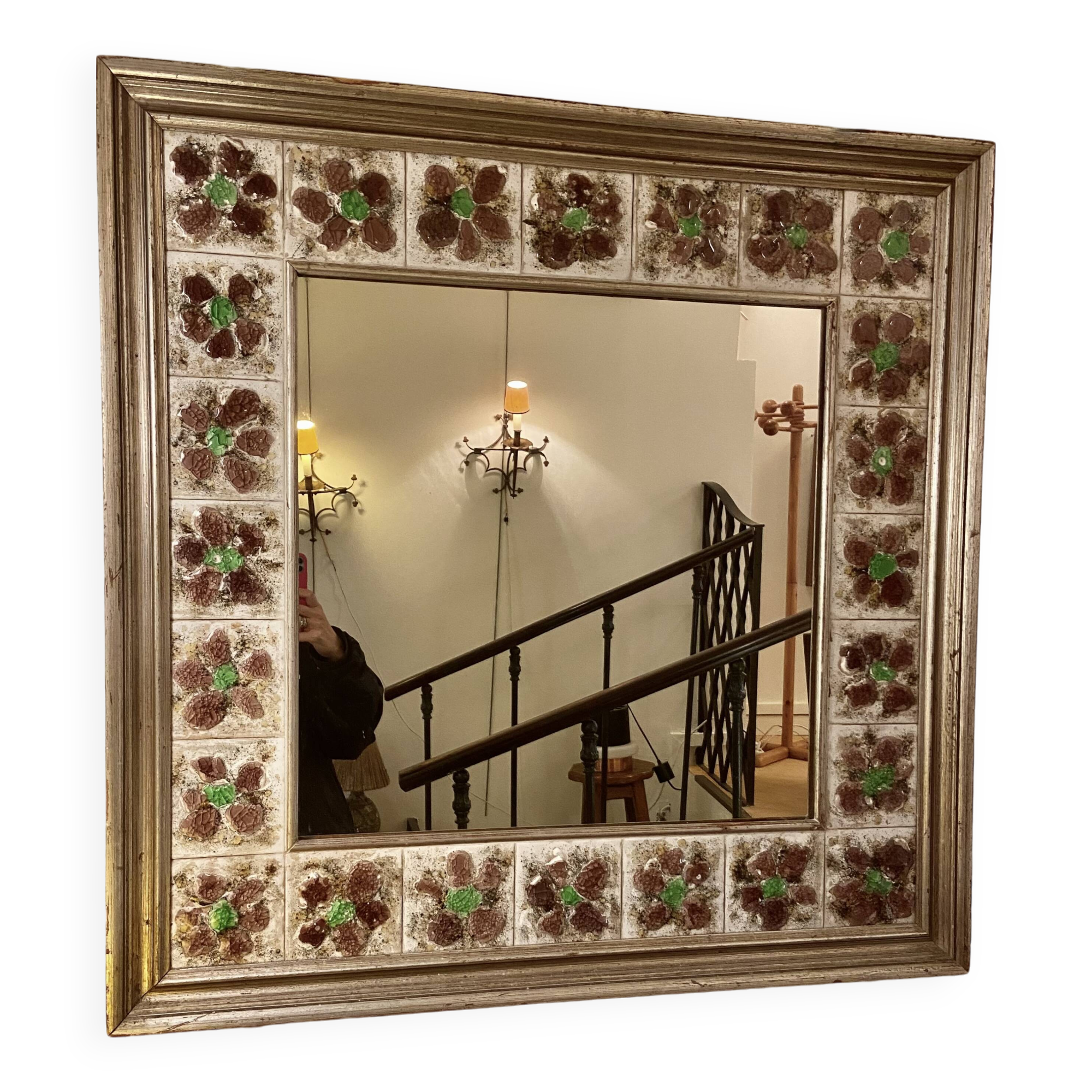 Large square ceramic mirror with floral decoration.