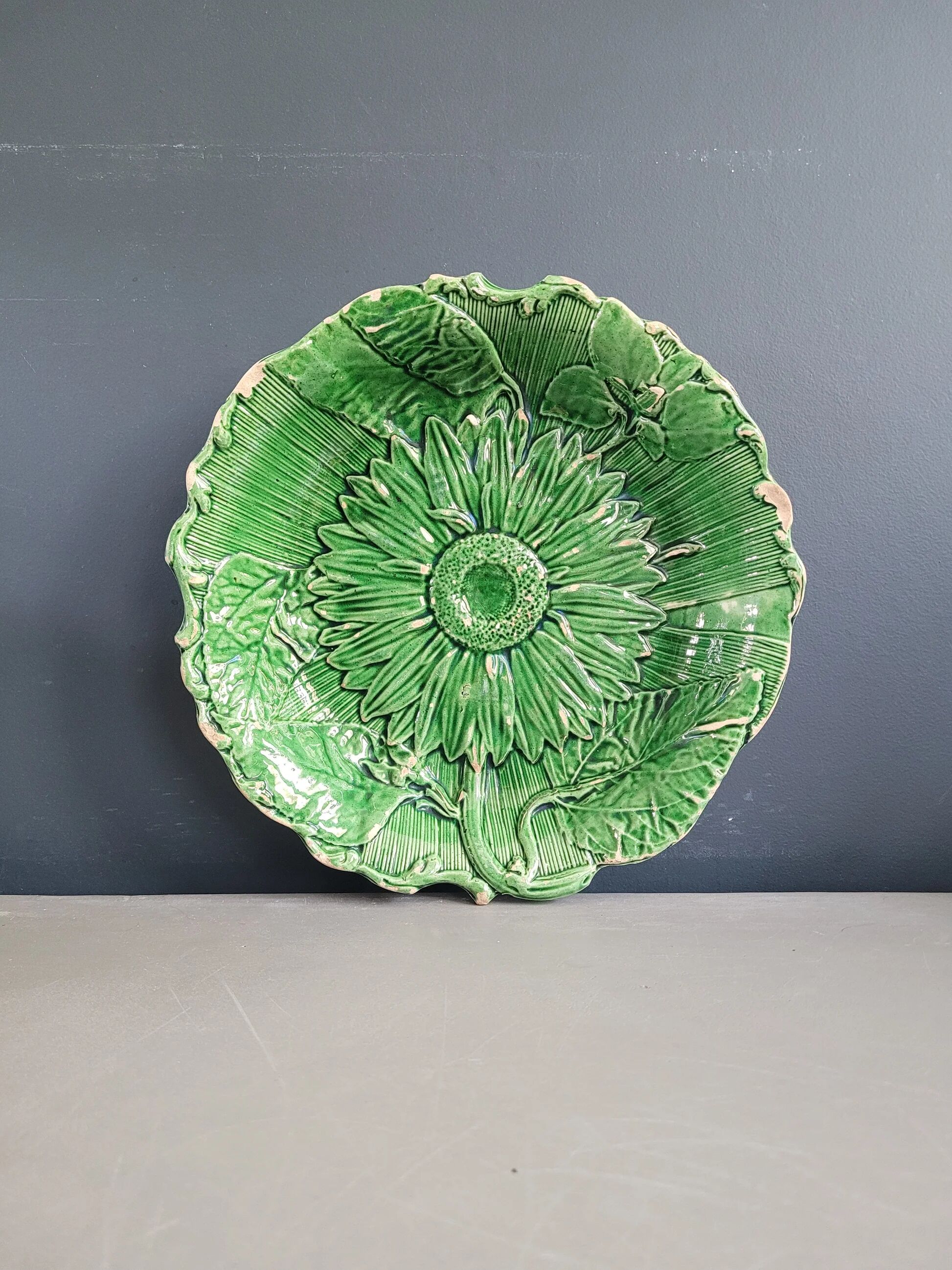 Plate decorated with a sunflower motif in slipware.