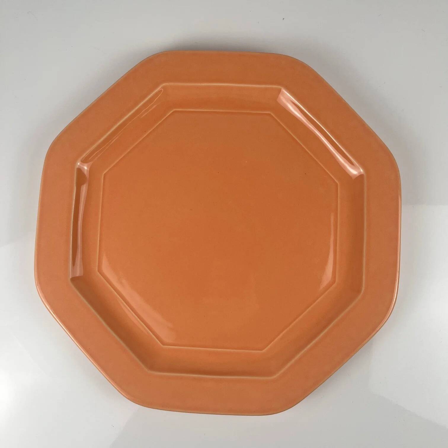 Octagonal plate in salmon pink, iron earth, Pagnossin, Italy, 20th century.