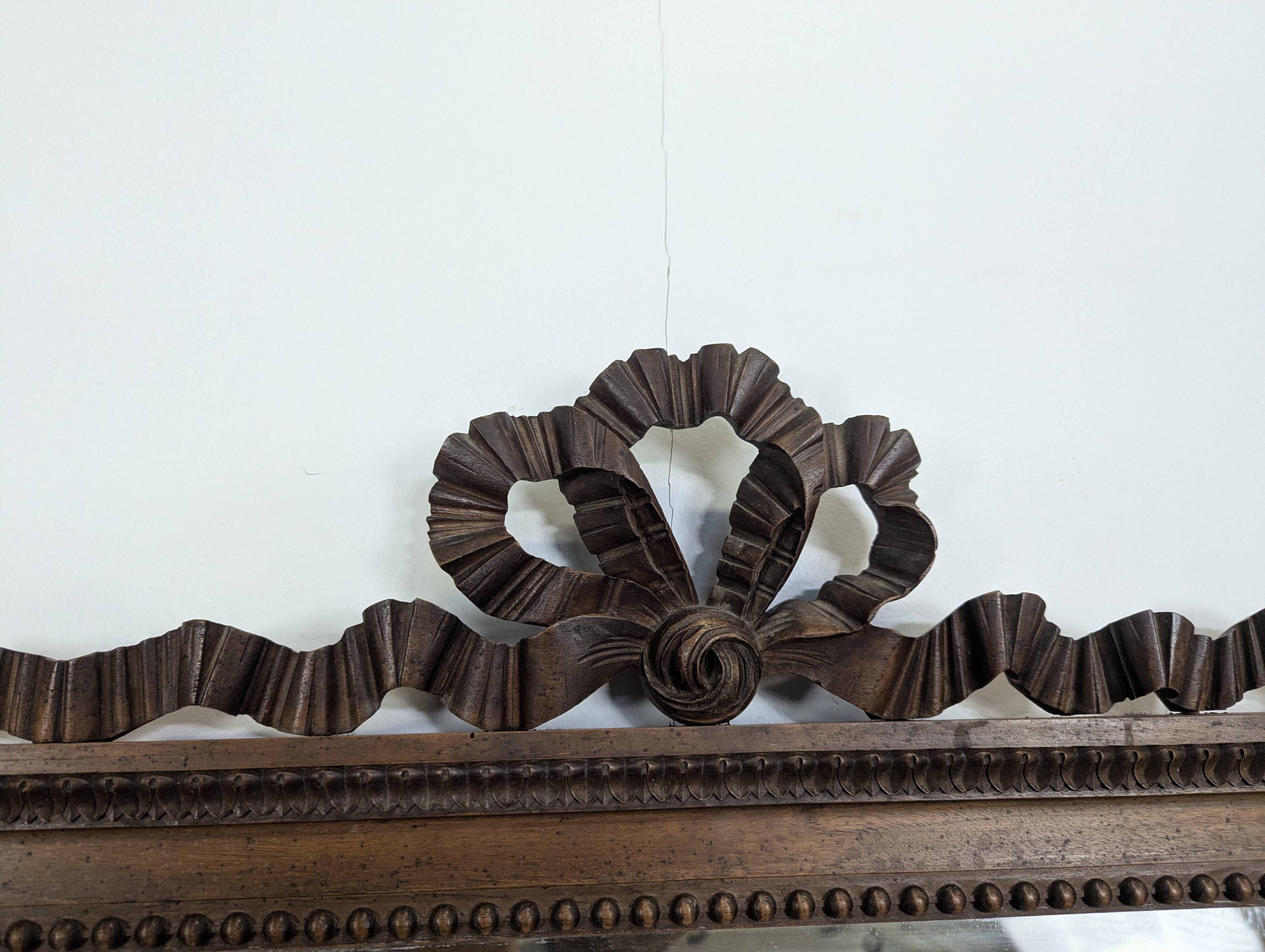Louis XVI style mirror in carved walnut.