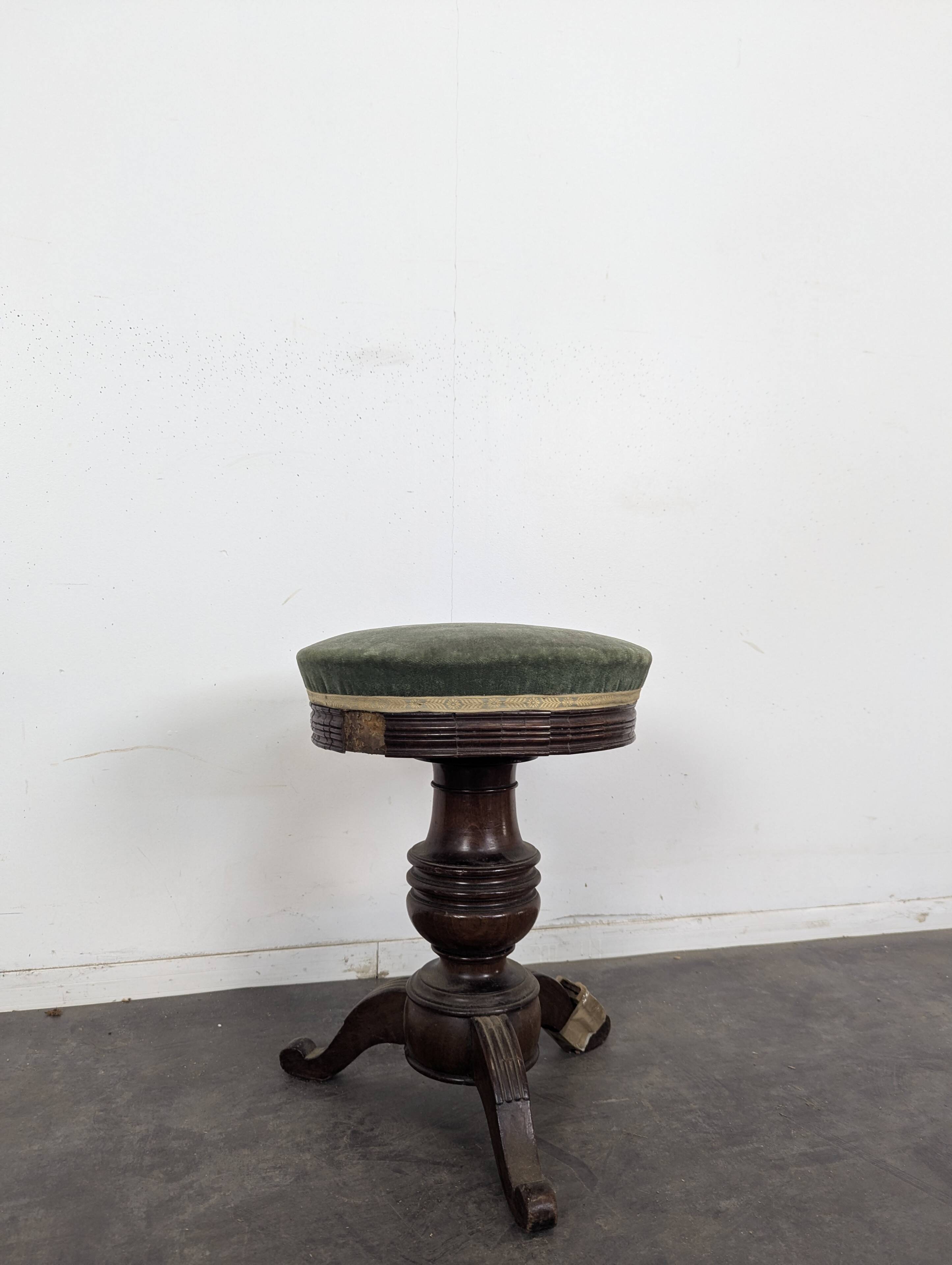Green velvet piano stool with a turned leg.