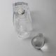 Vintage glass decanter from the 1980s, transparent glass with a silver plate and spherical stopper.