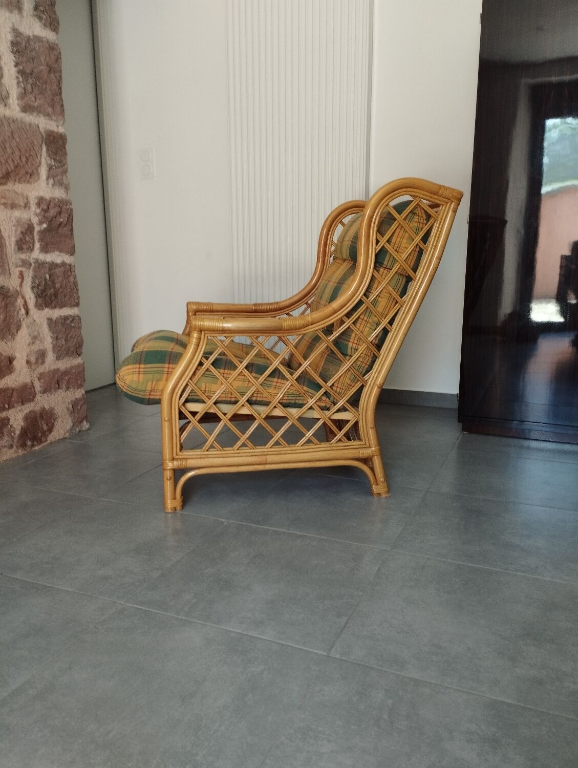Vintage armchair in bamboo and rattan with a tartan pattern.