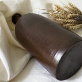 Old bottle in matte brown stoneware
