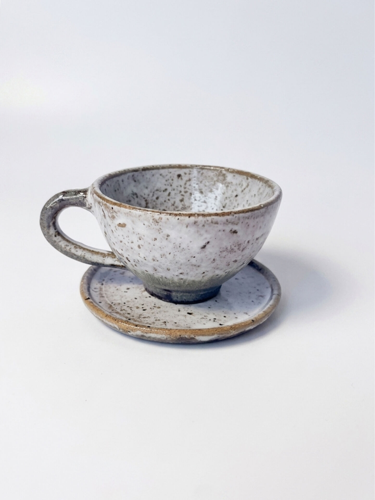 Handcrafted stoneware cup and its saucer – Speckled glaze