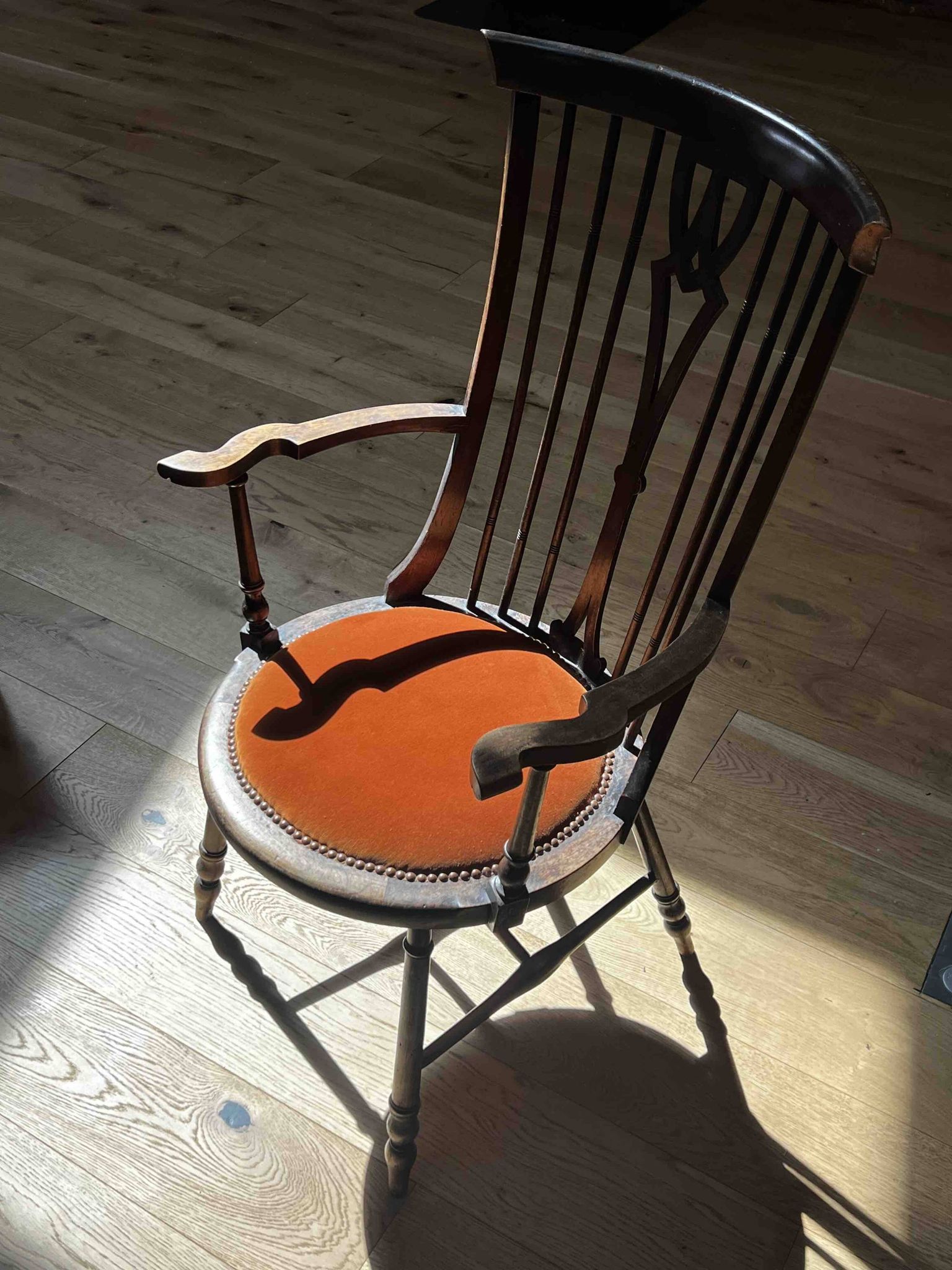Windsor chair with comb back, stained wood and terracotta velvet.