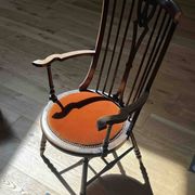 Windsor chair with comb back, stained wood and terracotta velvet.