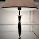 Contemporary table lamp in polished chrome with a conical fabric shade.