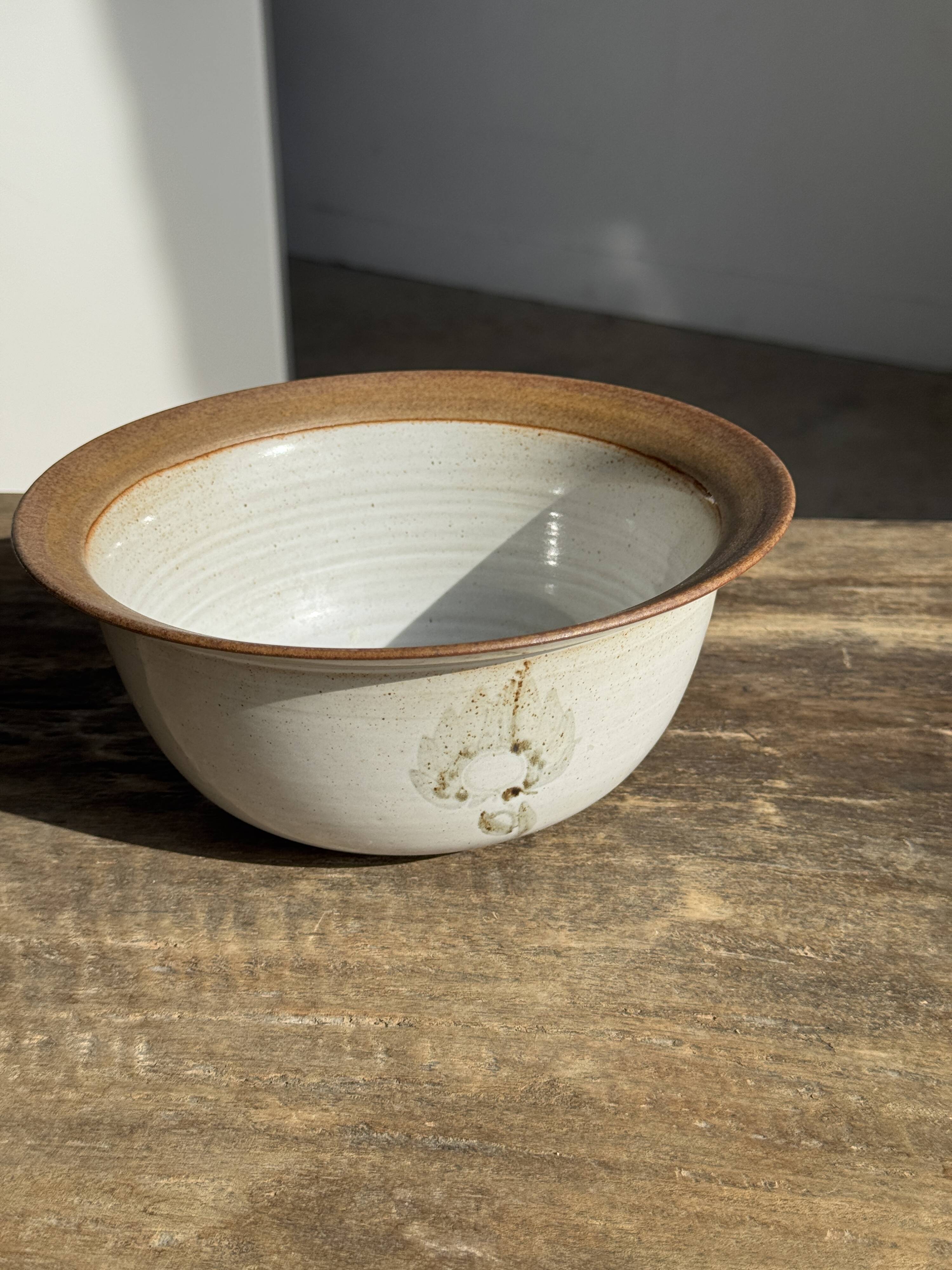 Small thick stoneware bowl with a stylised flower pattern in white on the outside, b