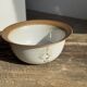 Small thick stoneware bowl with a stylised flower pattern in white on the outside, b