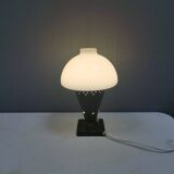 Small stylish table lamp with perforations and milky white opal glass shade