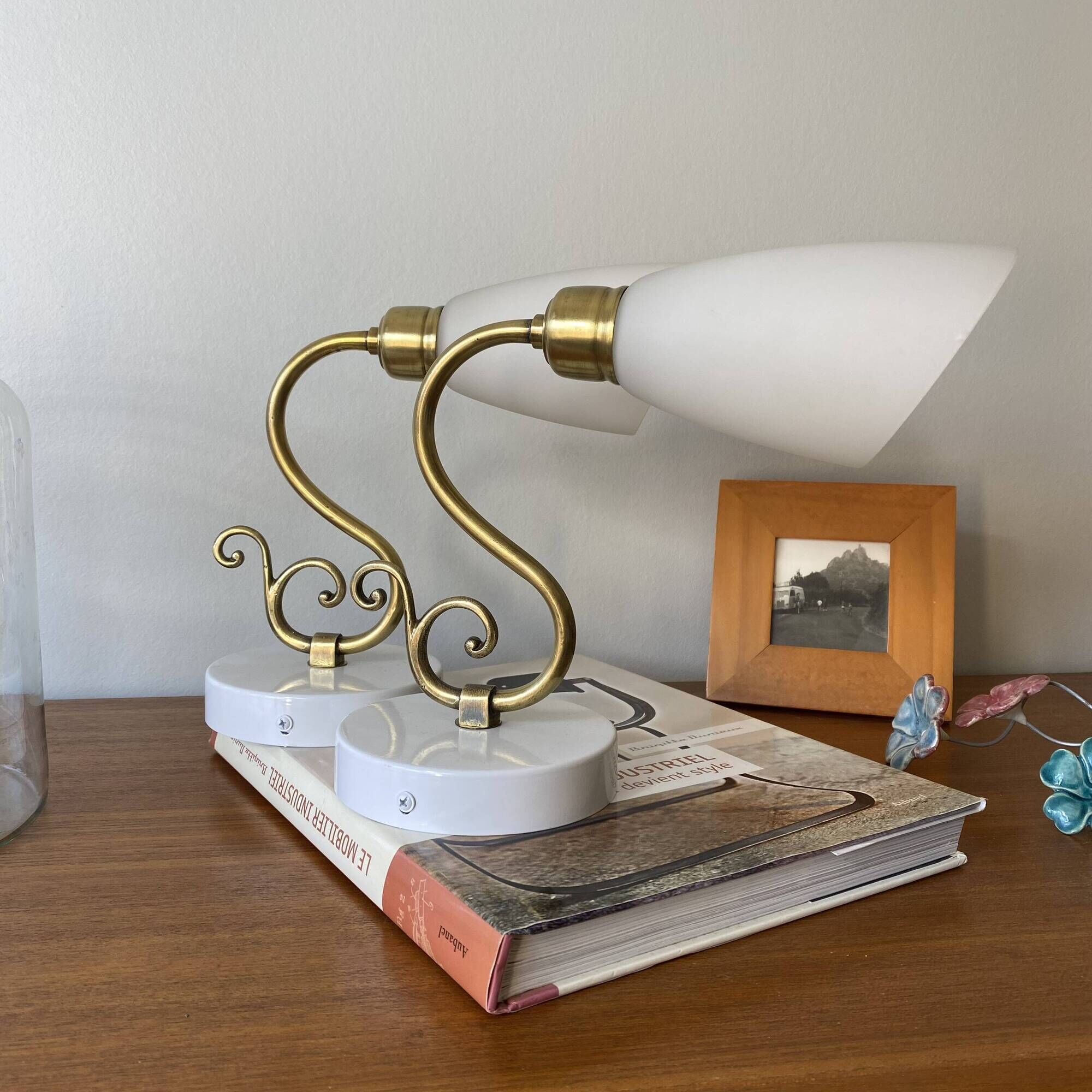 Pair of brass swan neck wall lights with white glass shades.