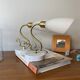 Pair of brass swan neck wall lights with white glass shades.