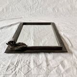 Vintage wall mirror in varnished steel decorated with a rose in relief