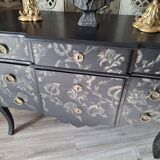 Large black chest of drawers with golden floral decoration