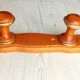 Wall-mounted coat rack in wood and brass