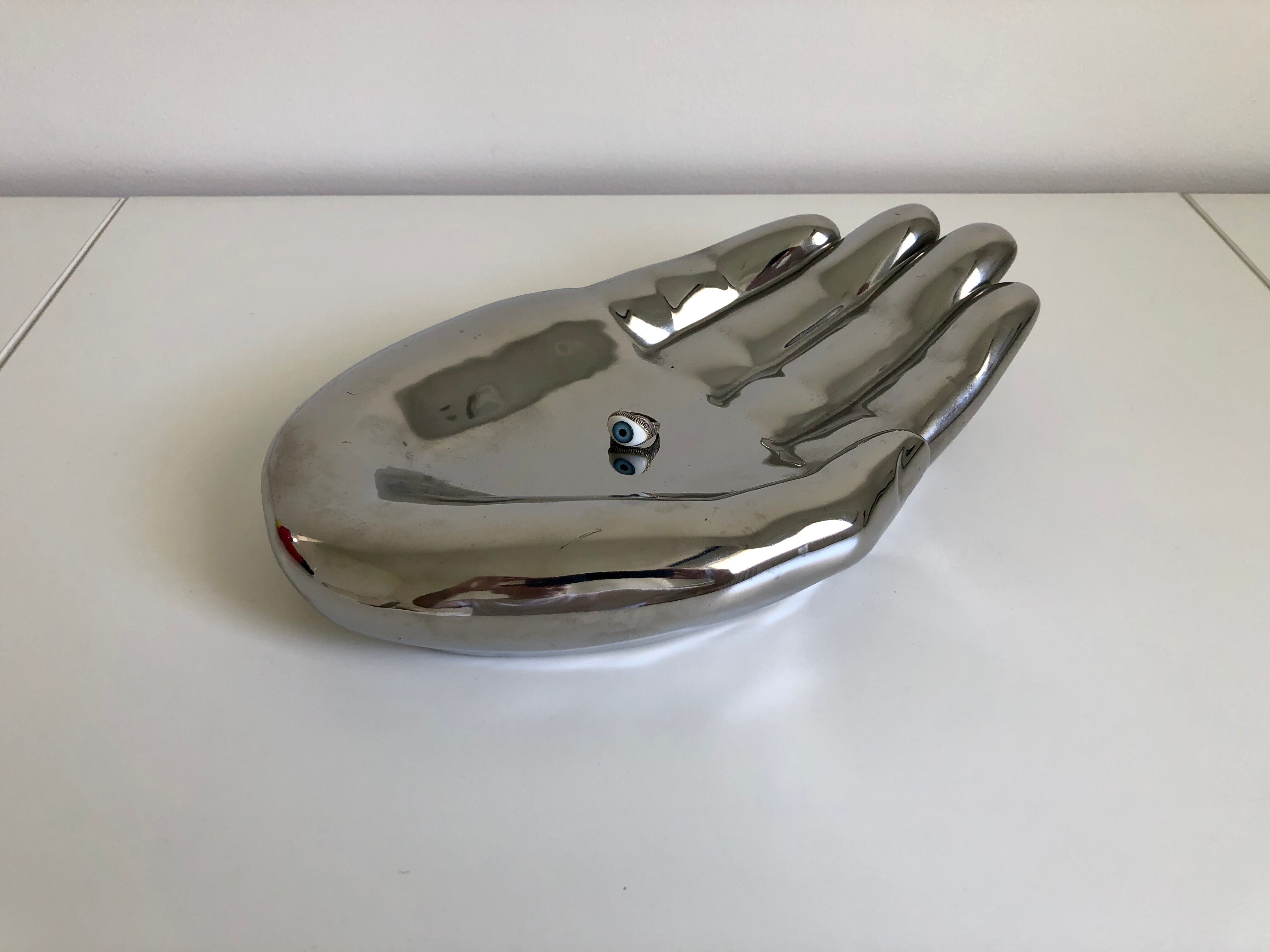 Empty silver chromed ceramic pocket in the shape of a large hand, 1980