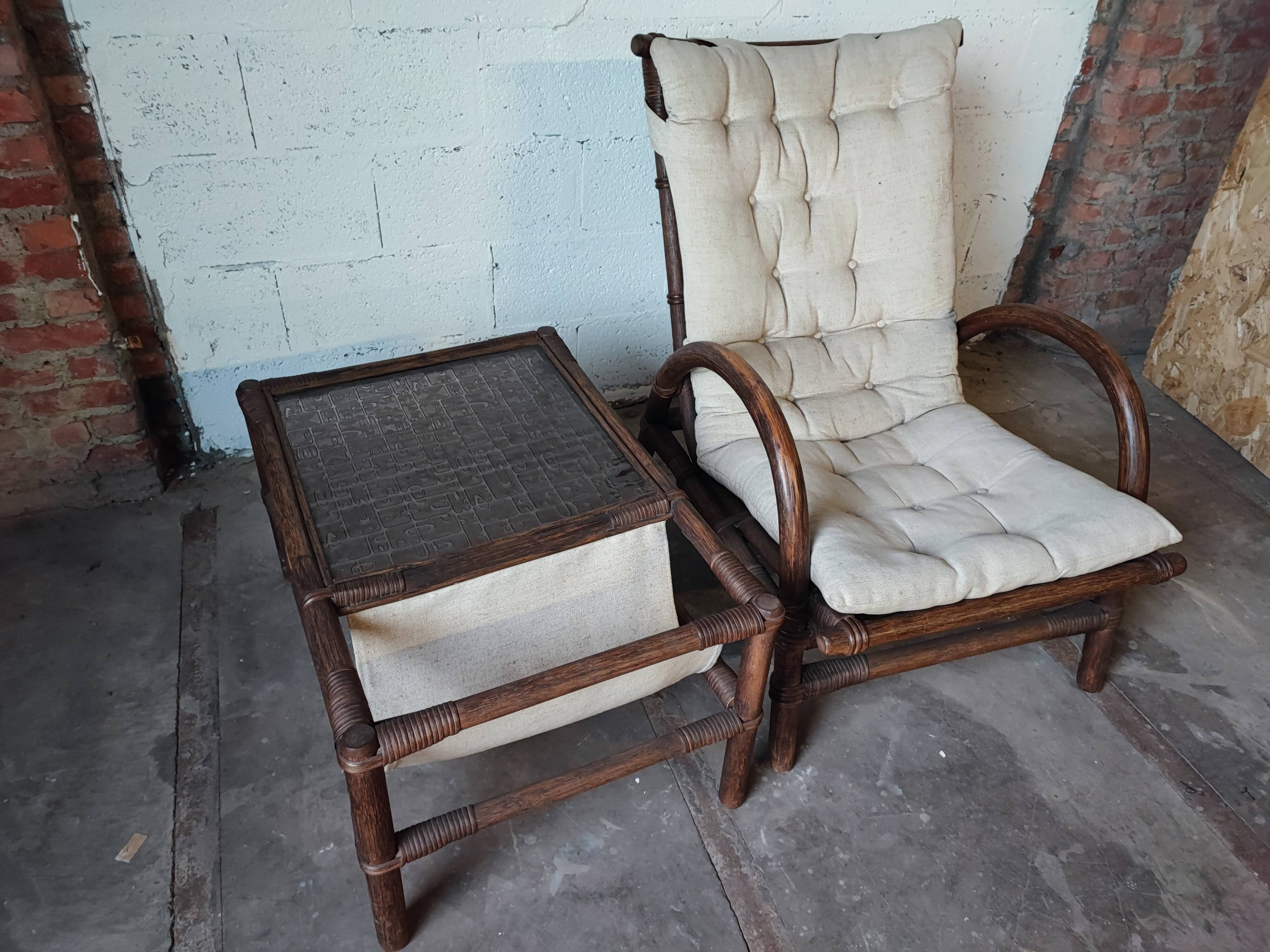 Relaxed armchair in bamboo and rattan with its small side table. Beige linen cushion.