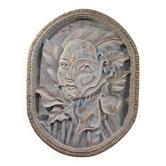Sculpture en bas-relief, visage stylisé avec des fleurs, 20e siècle