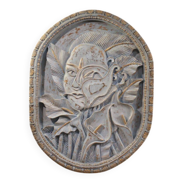 Bas-relief sculpture, stylized face with flowers, 20th century