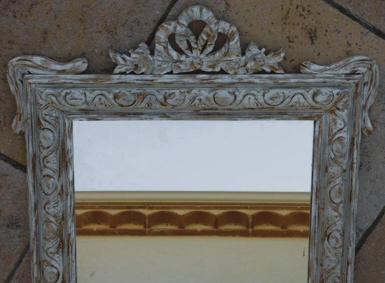 Chic and stylish antique mirror with carved wooden frame in whitewashed