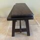 Small antique wooden bench with a folding backrest.