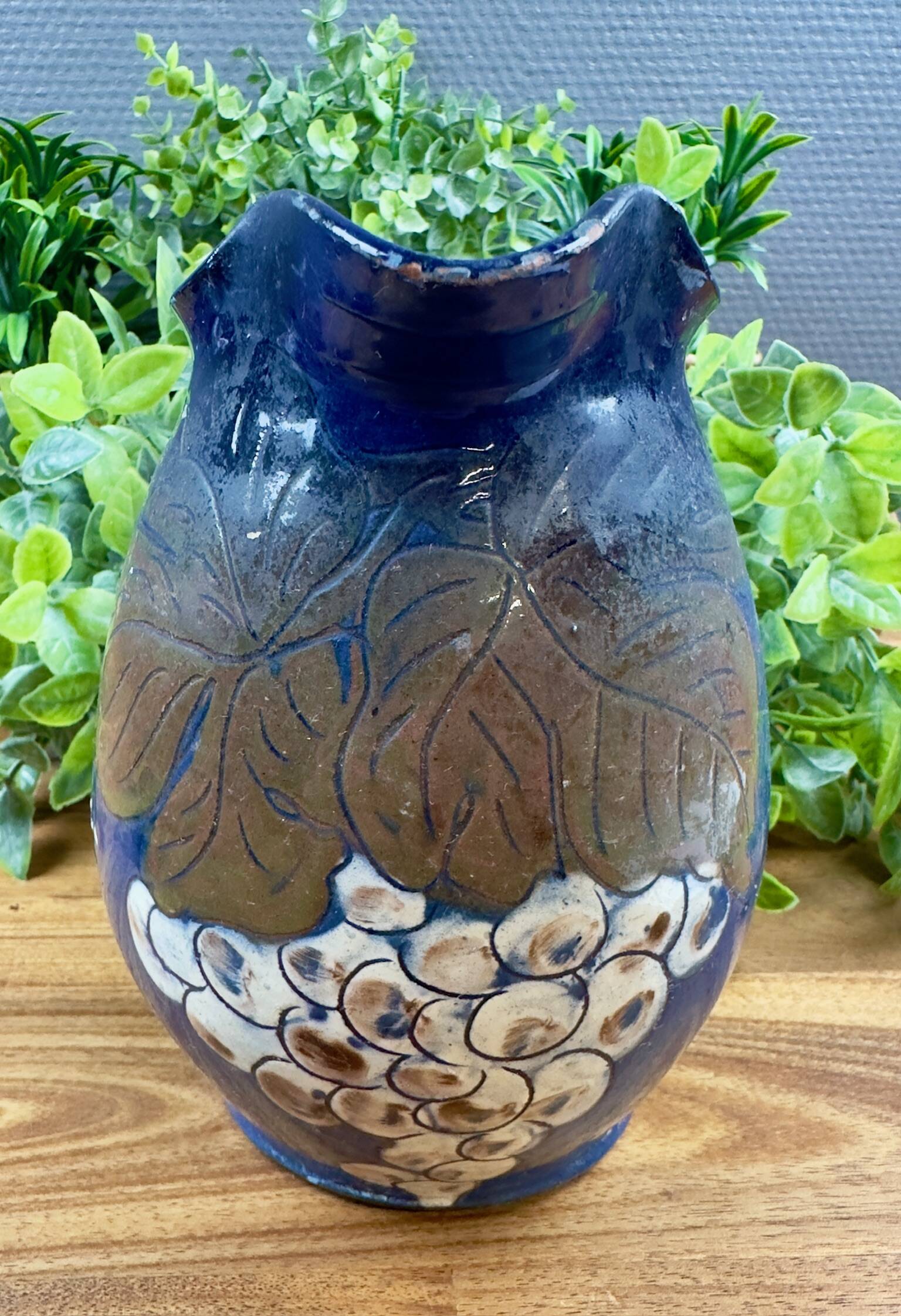 Blue ceramic pitcher with vintage artisan inscription decoration.