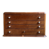 Small storage unit with 4 drawers in dark wood and Antoinette Poisson wallpaper.