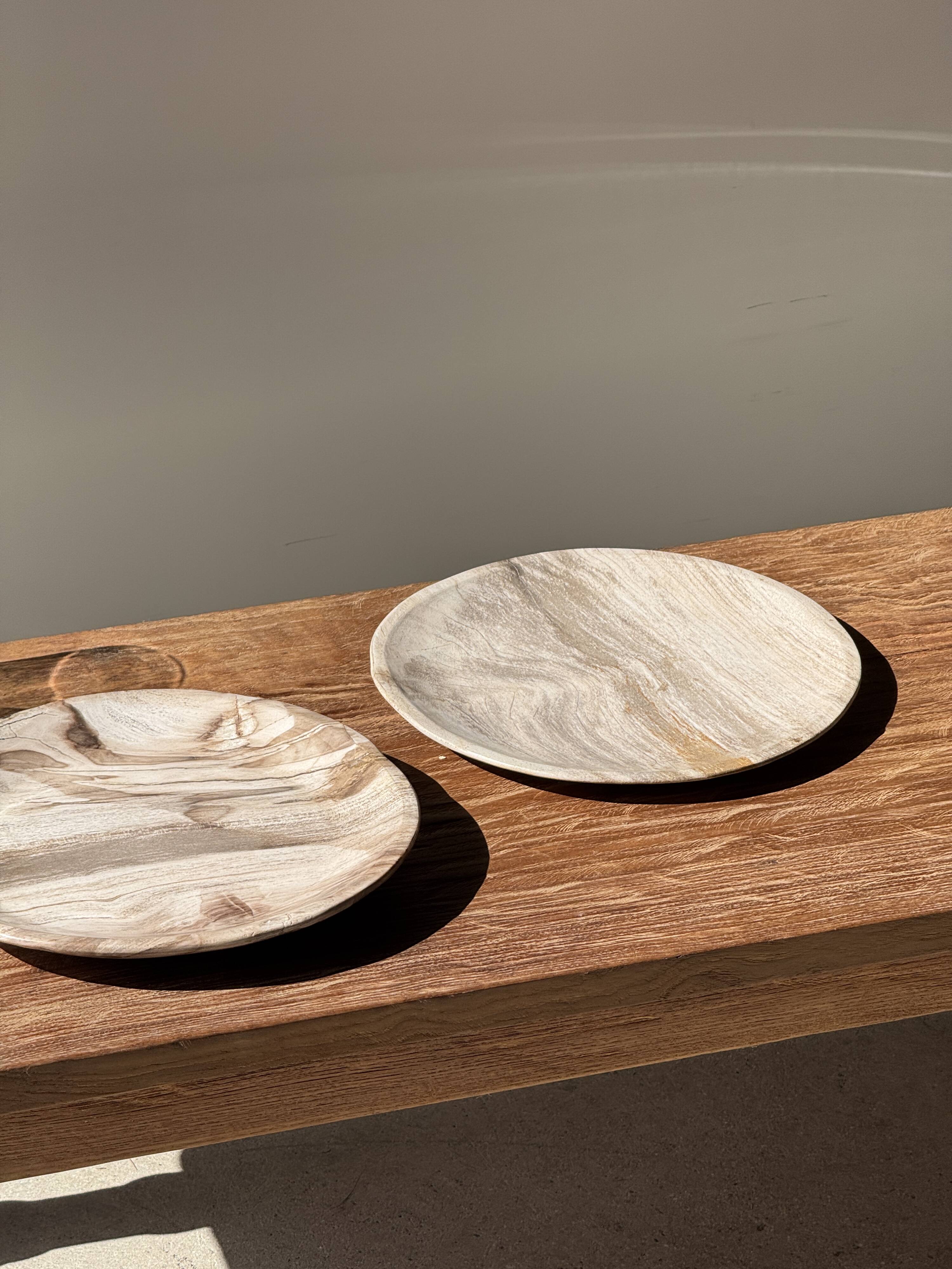 Tray, circular dish or plate made of white striped grey petrified wood.