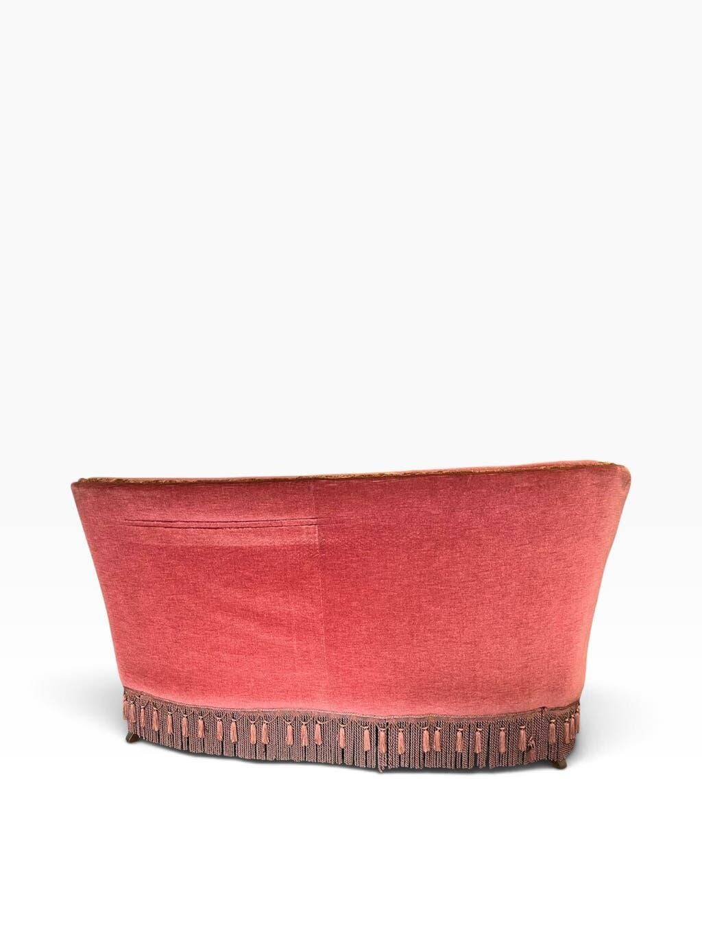 Vintage two-seater armchair in powder pink velvet with fringes.