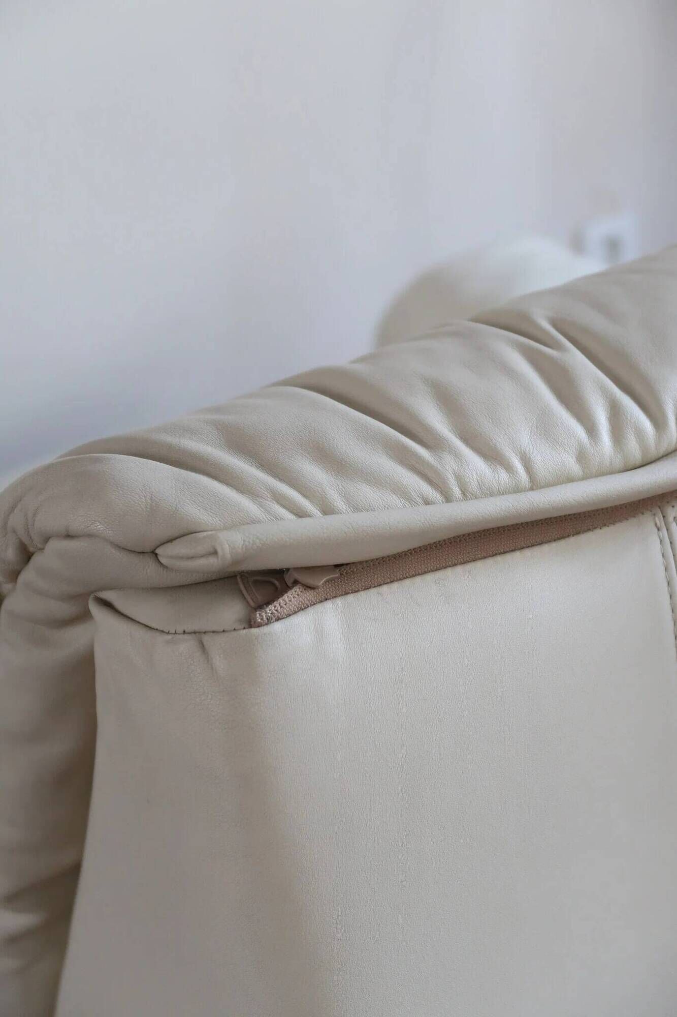 Cinna armchair in cream leather, bolstered armrests, 1970s.