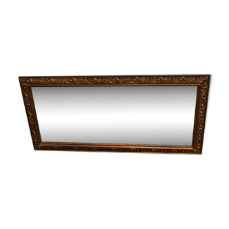 miroir mural dans un cadre décoratif en bois.