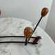 Wall-mounted coat rack in wrought iron with turned wooden knobs.