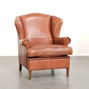 Light cognac-coloured English wingback armchair made of cowhide leather
