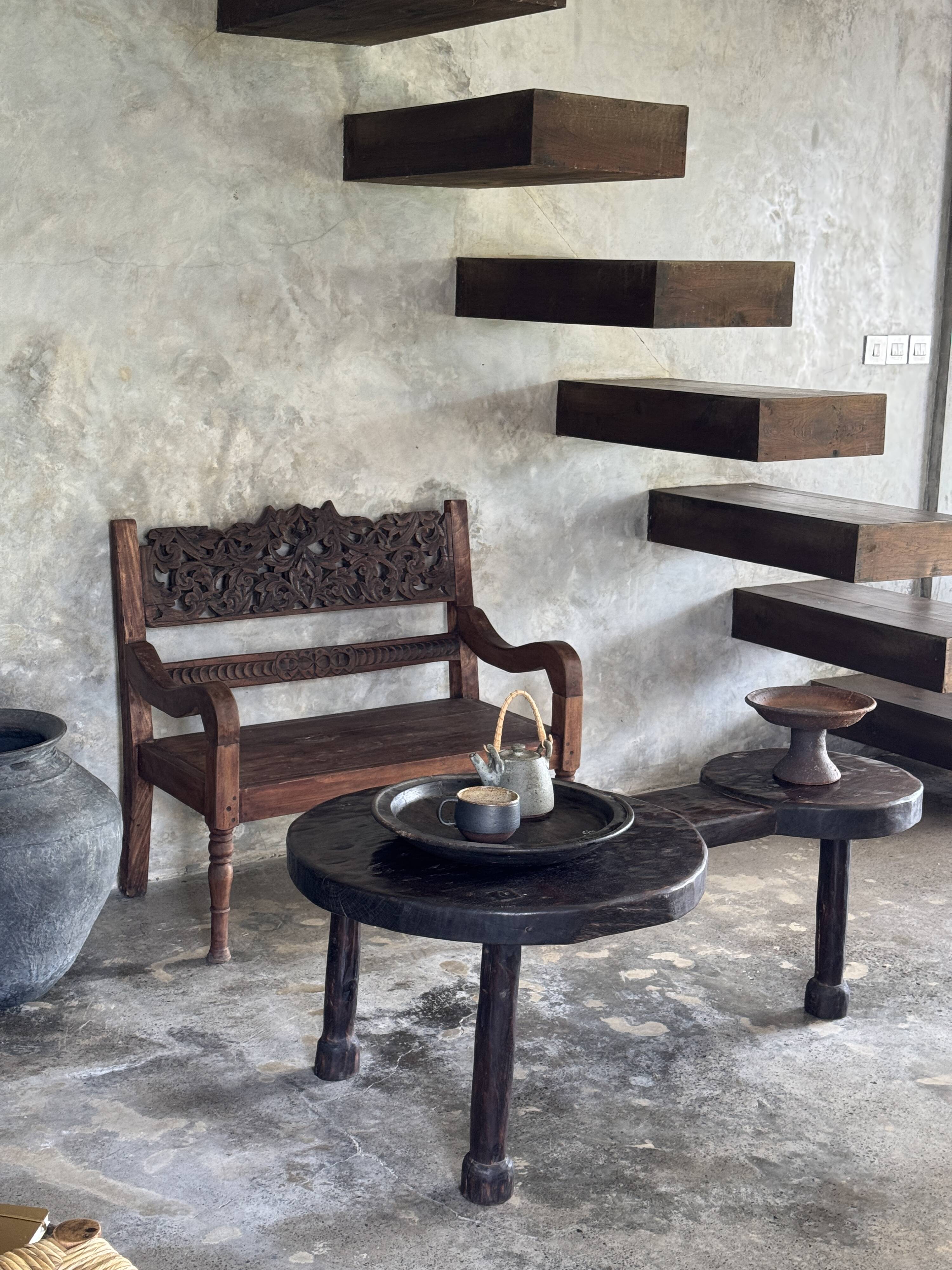 Small antique Indonesian bench in carved teak with plant and floral motifs.