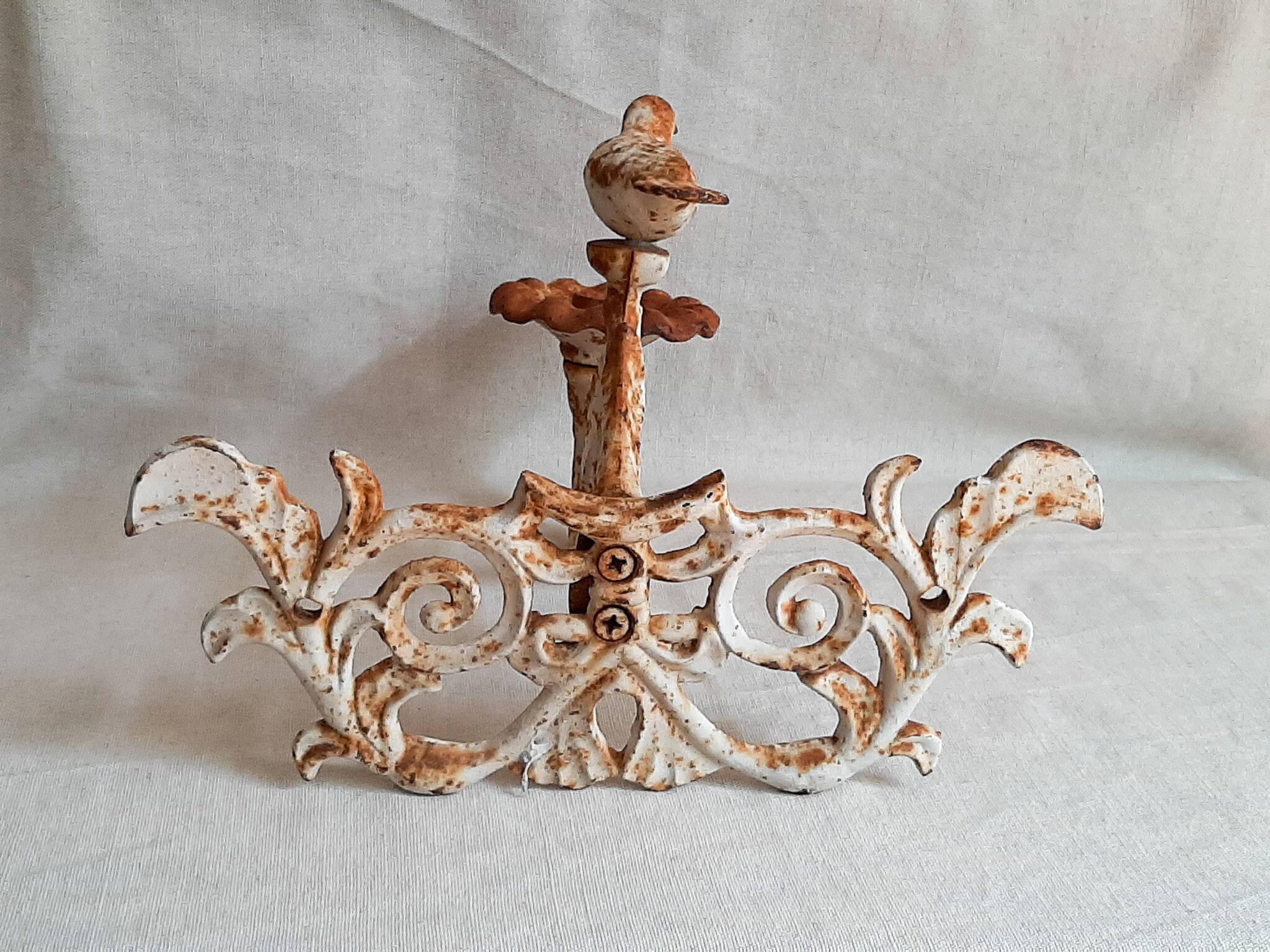 Wall lamp in antique cast iron with bird and scroll decorations.
