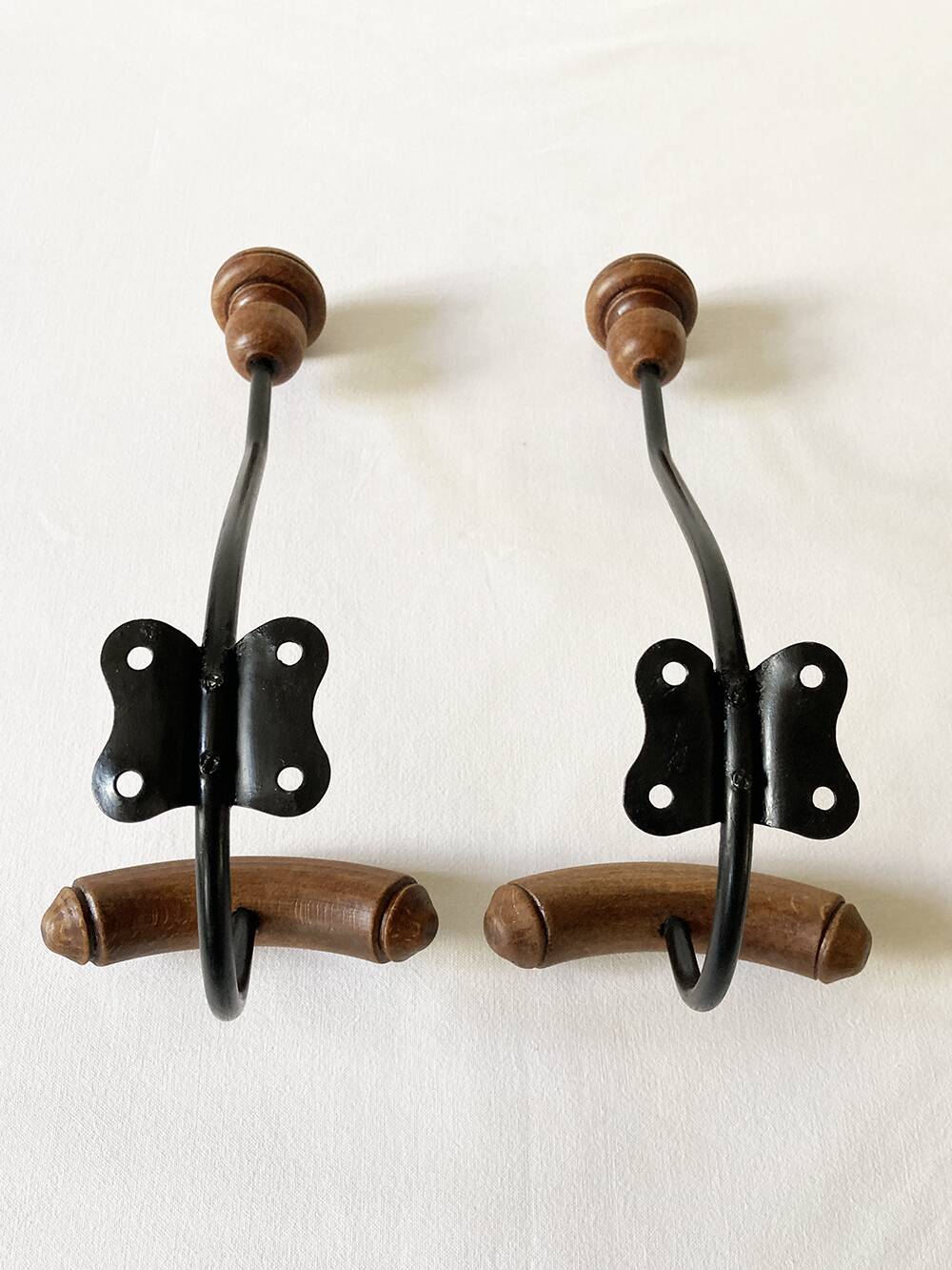 Pair of antique wooden and metal coat hooks