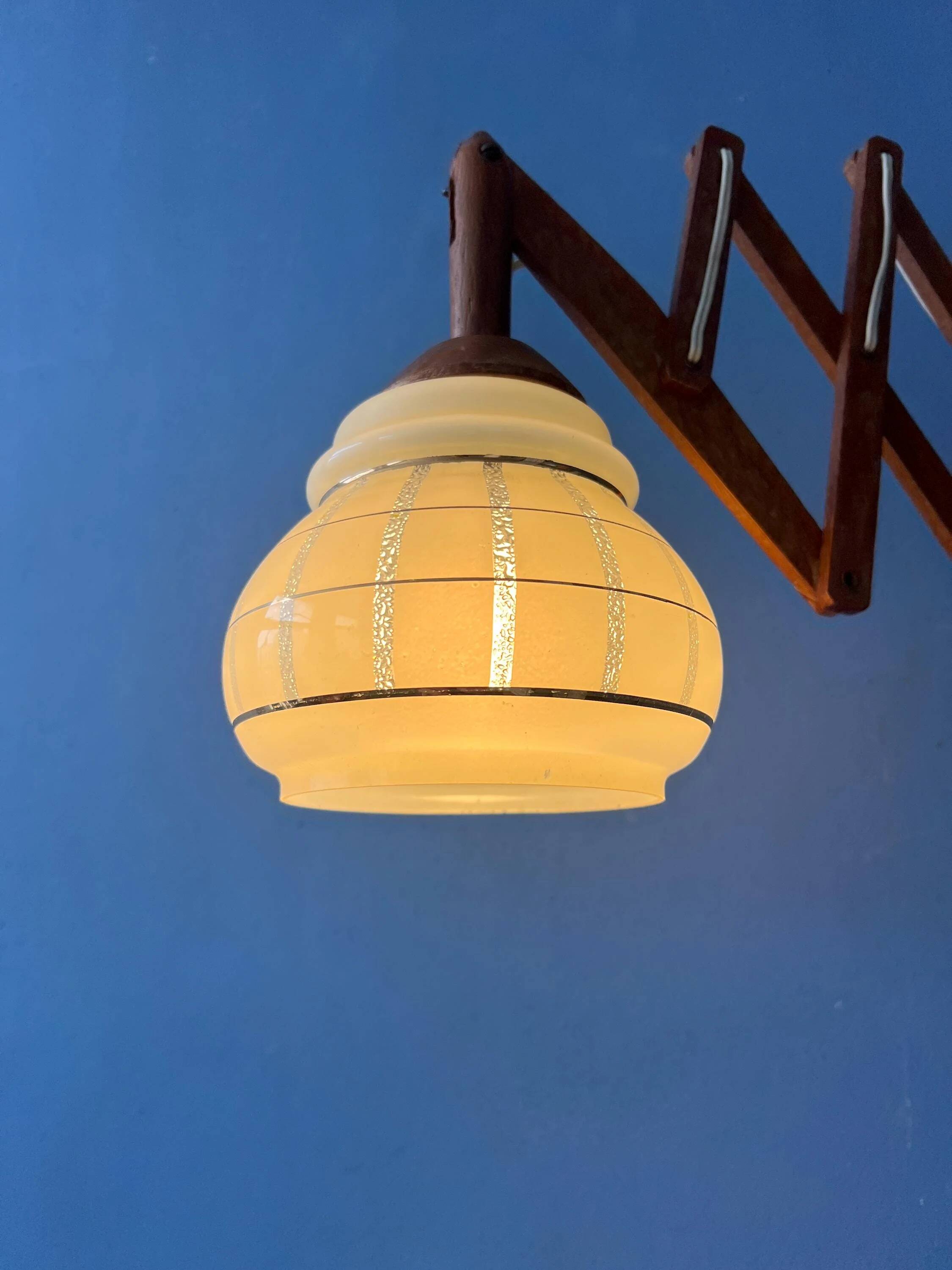 Vintage wall lamp with teak wood scissors and glass shade.