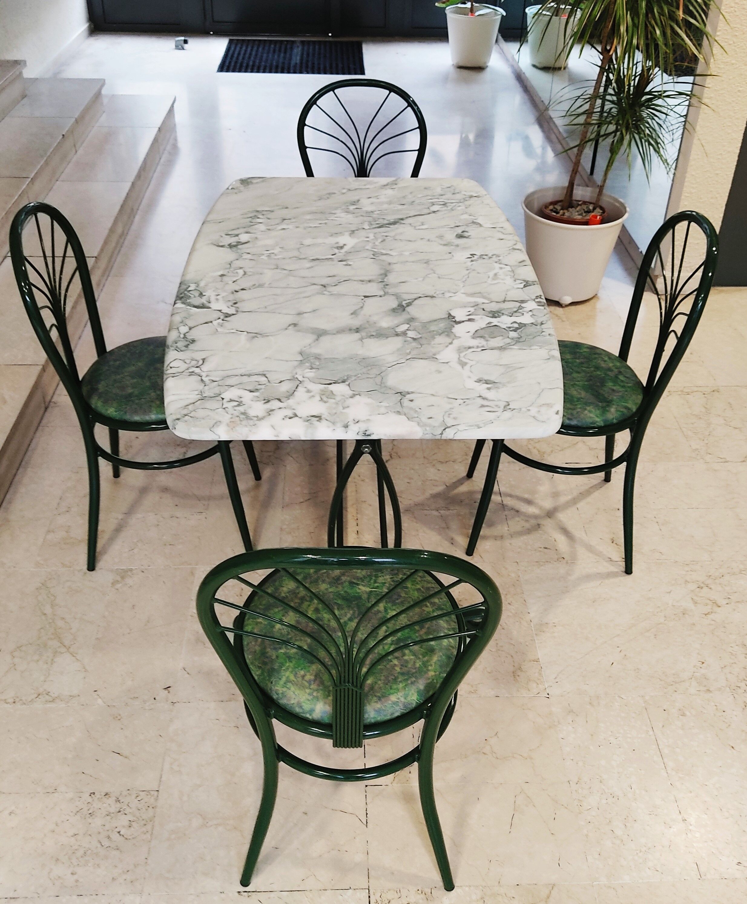Table à manger en marbre, pieds fonte verts et 4 chaises tube acier assorties revêtement simili cuir