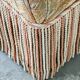 Pair of sculptural Hollywood Regency lounge chairs with original fringed upholstery