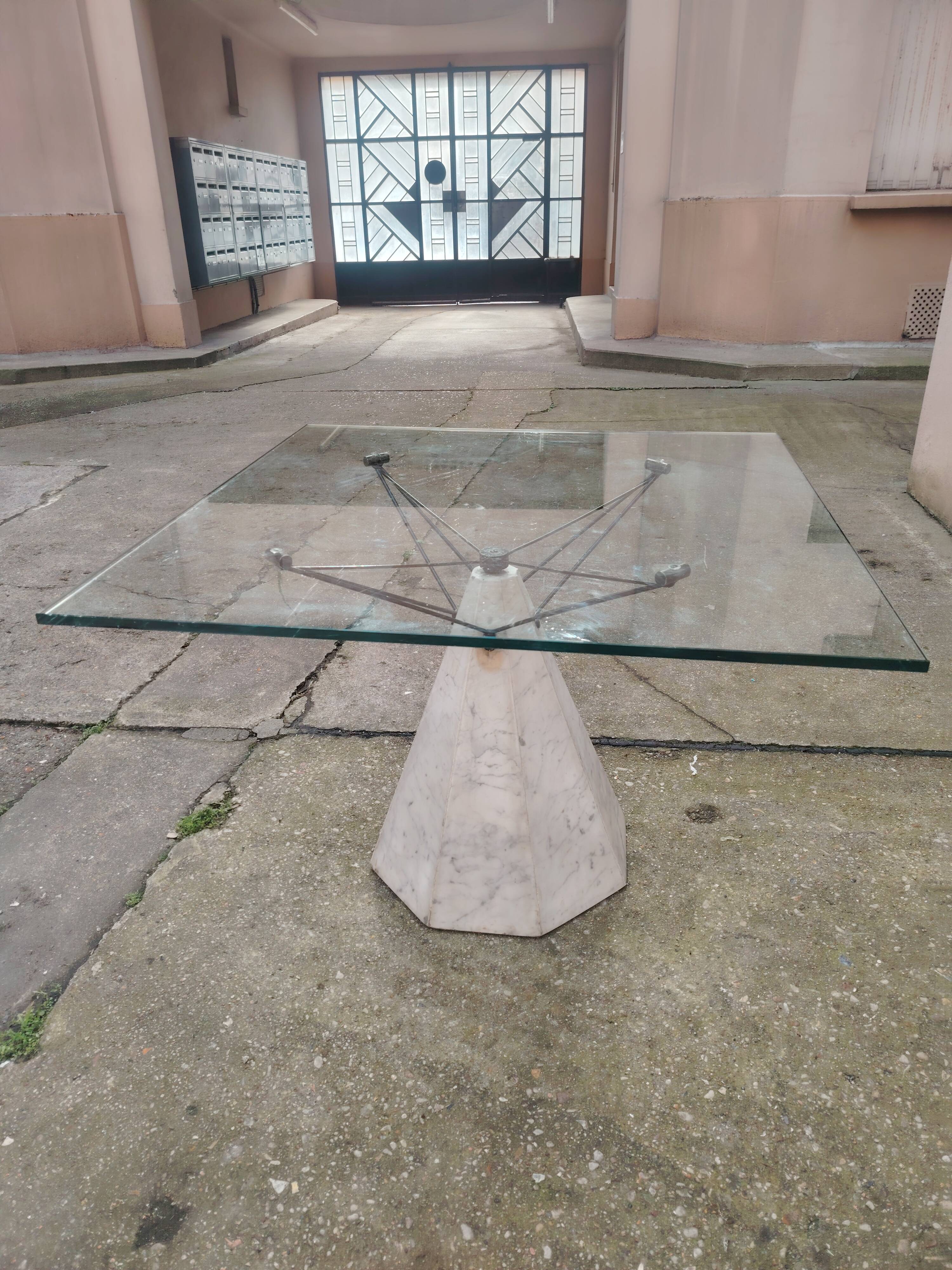 1980s table with a marble and steel base and a square glass top.