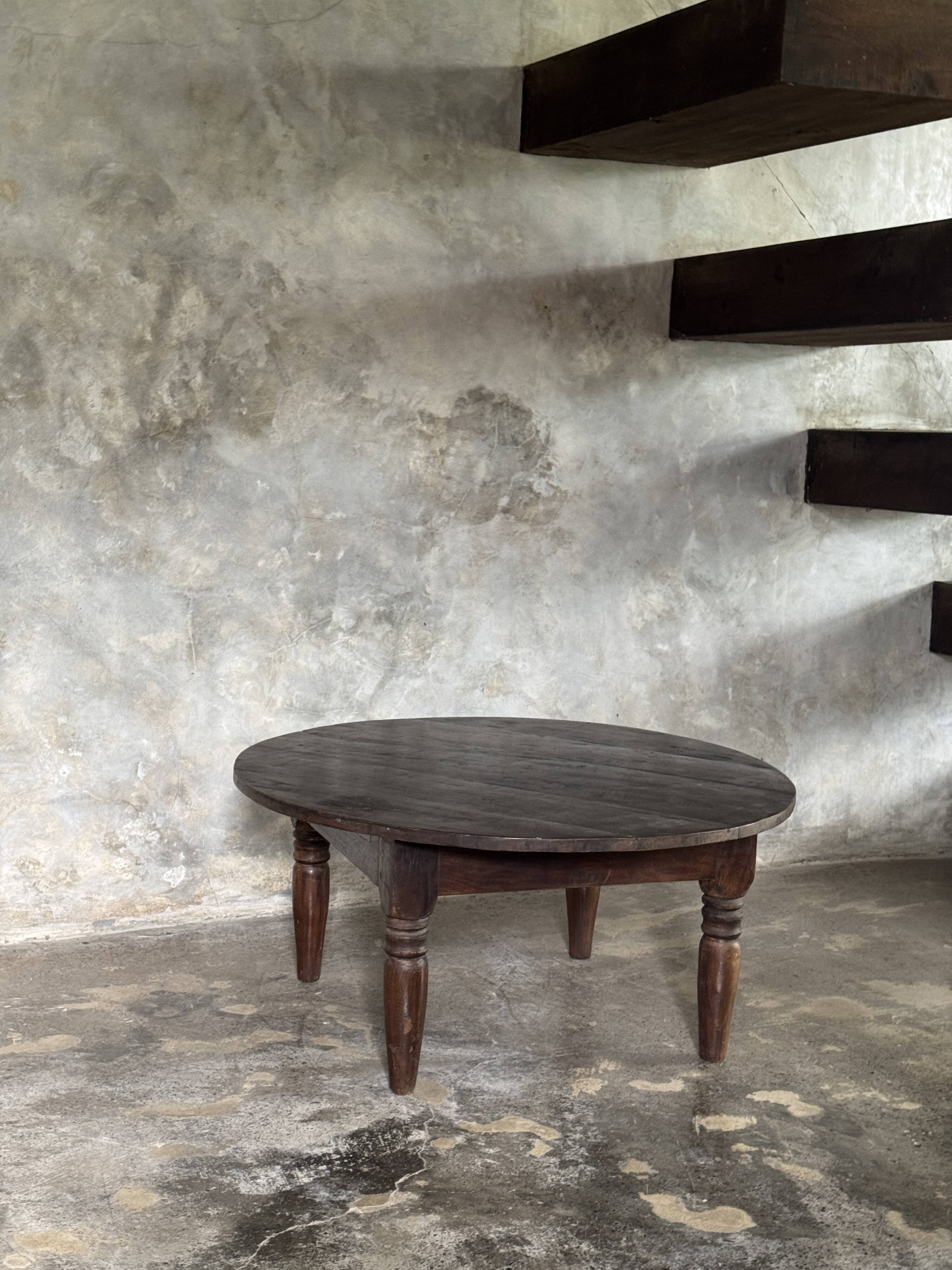 Coffee table, round antique Indonesian teak table with straight legs.