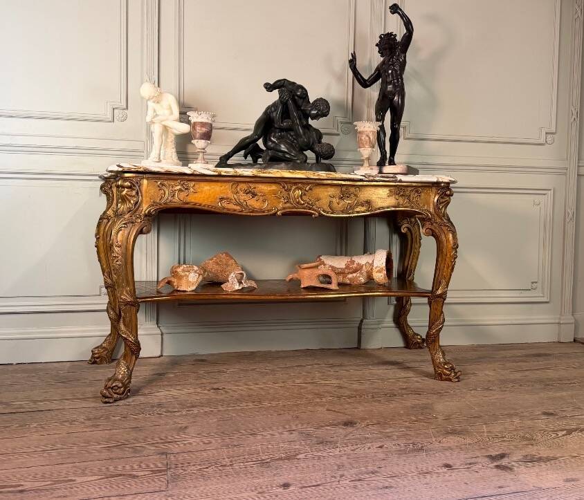 Golden wooden console, four legs adorned with sea monsters, purple breccia marble, around 1900.