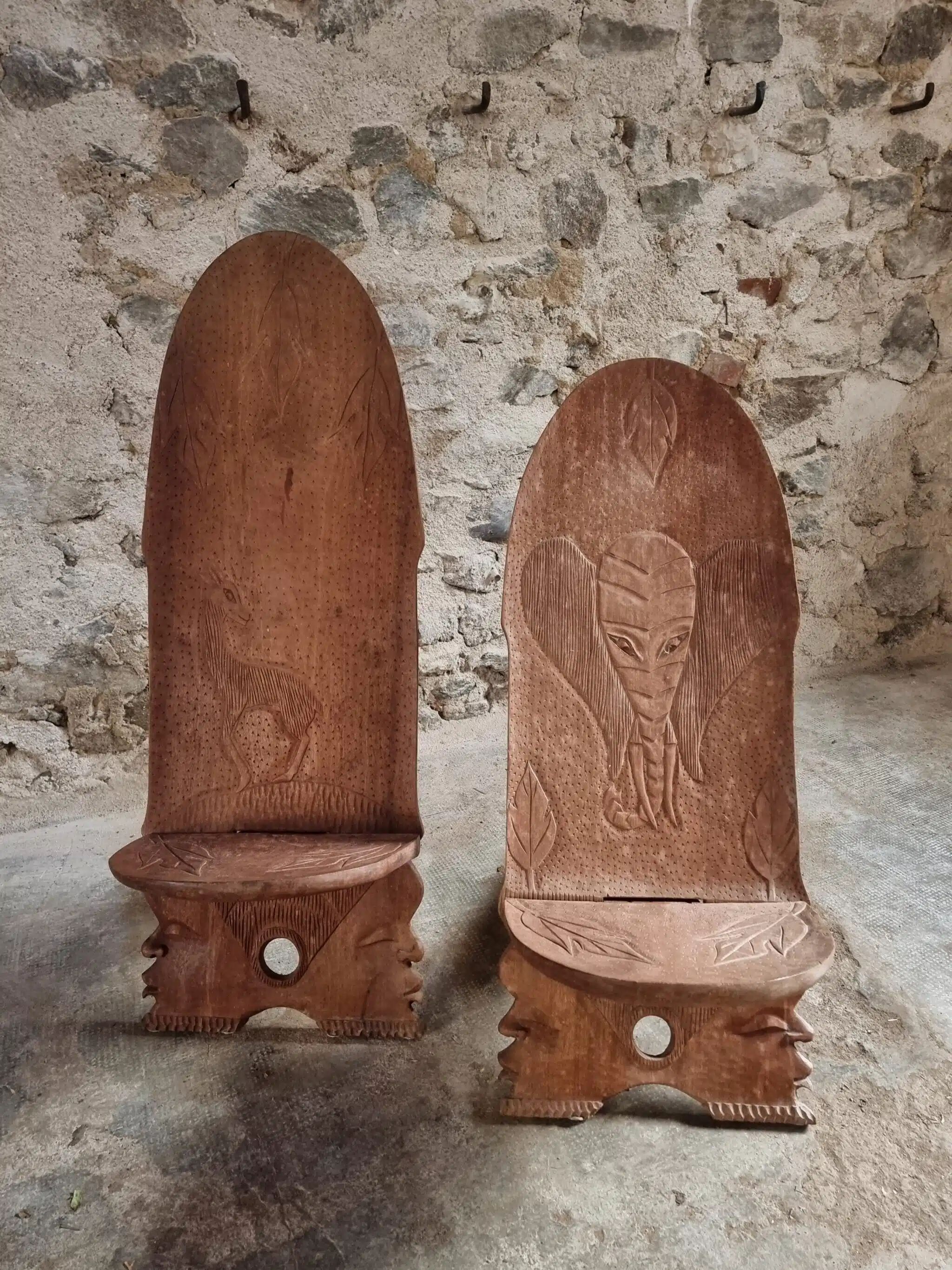 Pair of hand-carved wooden folding chairs – African origin, animal and face motifs, mid-20th century