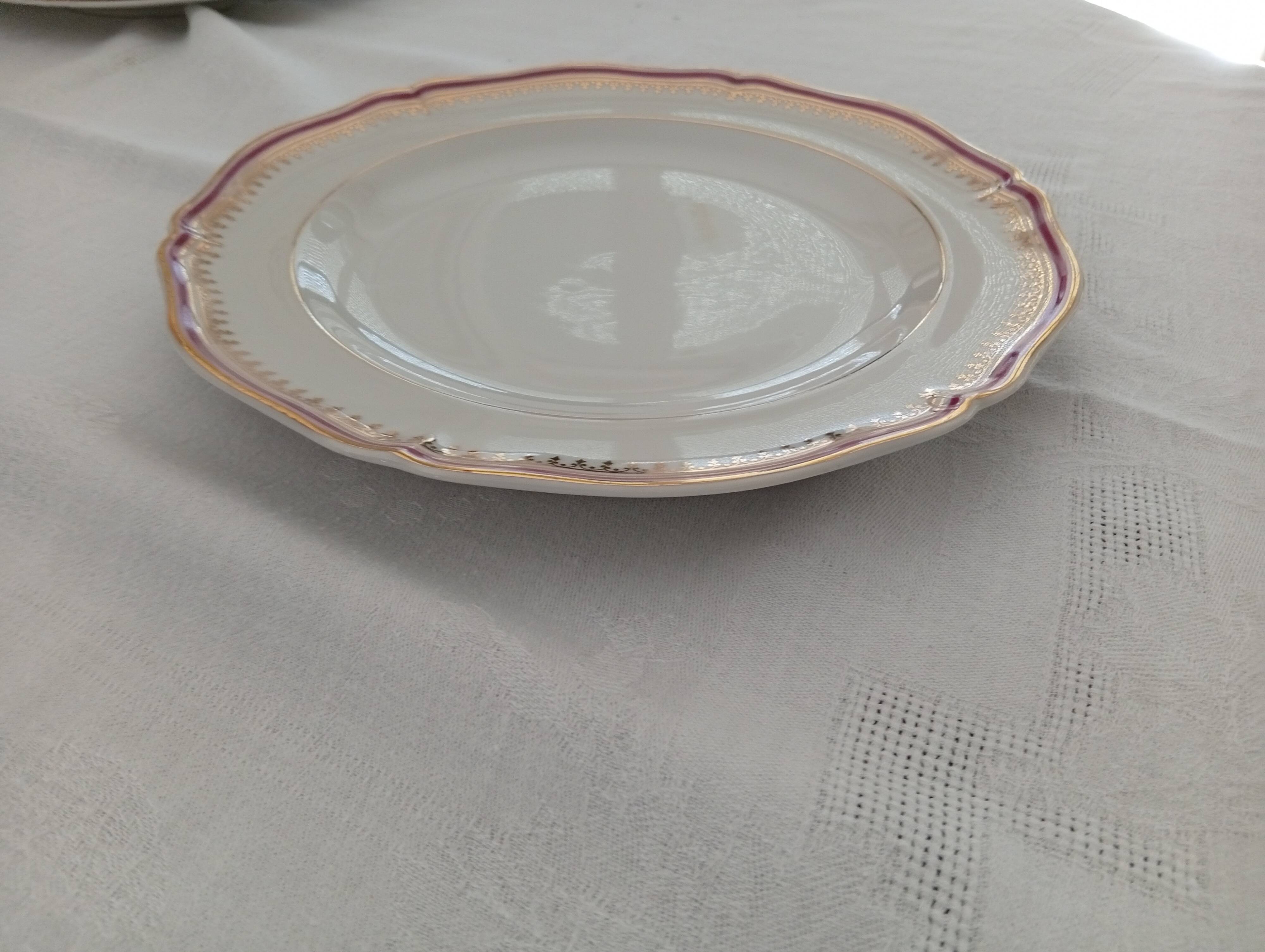 Set of 12 stylised white porcelain dinner plates, signed.