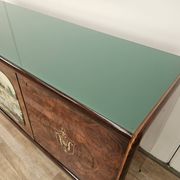 1950s mahogany sideboard with a glass top and central bar.