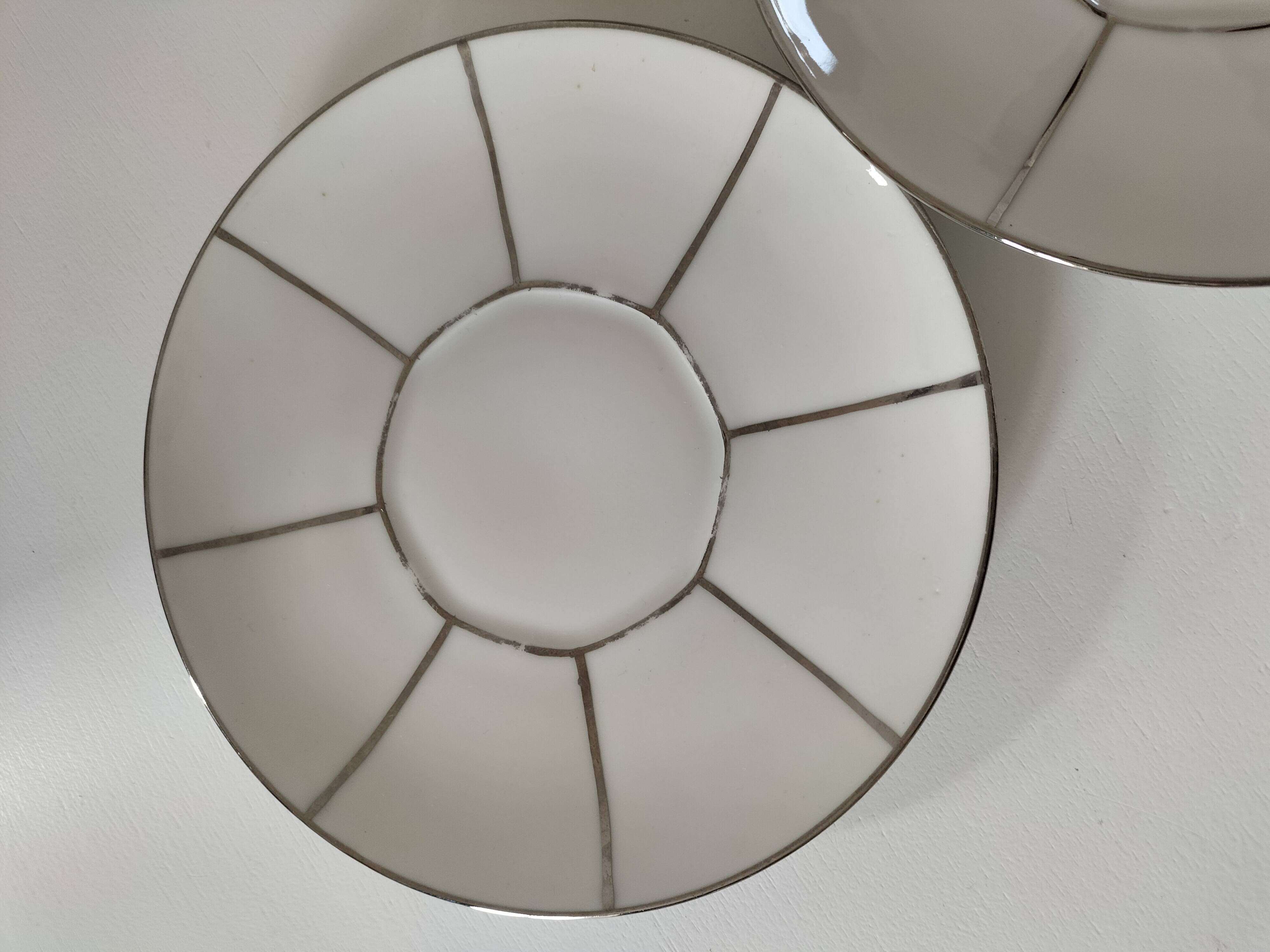 Two Art Deco porcelain cups and saucers with silver trim.