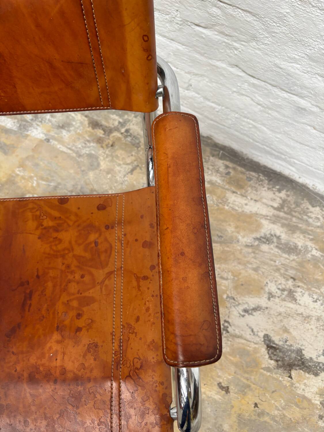 Vintage aluminum tube and tan leather armchair