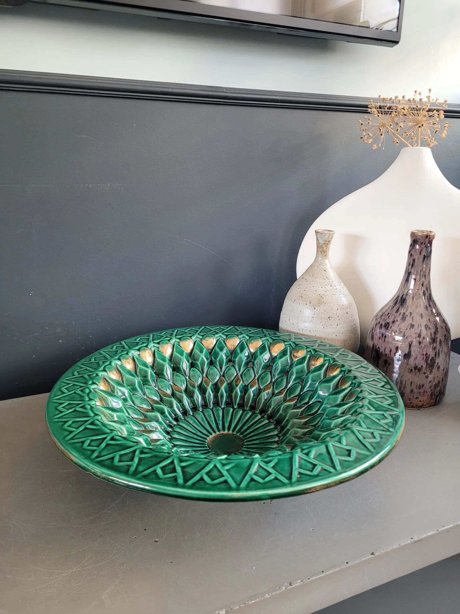 Large pierced earthenware fruit bowl glazed in green and gold.