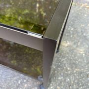 Vintage 1970s rolling bar cart made of metal and smoked glass.